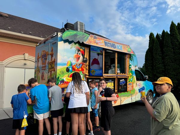 Children enjoying treats from the ice truck on a summer evening