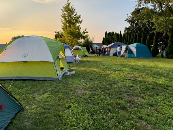 A row of tents on the church lawn at sunset